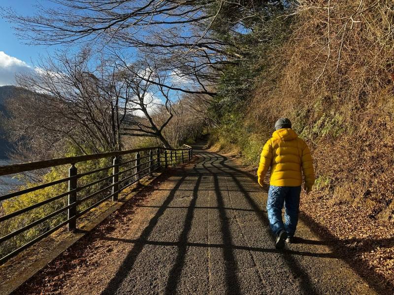 A guest walking beside Lake Ashi on a clear winter day